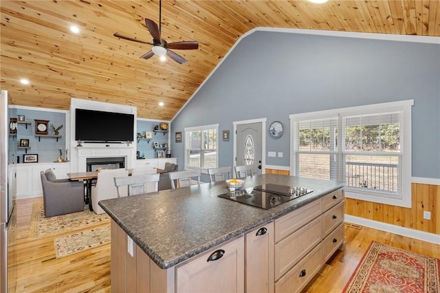 kitchen with black electric stovetop, high vaulted ceiling, plenty of natural light, and a kitchen island