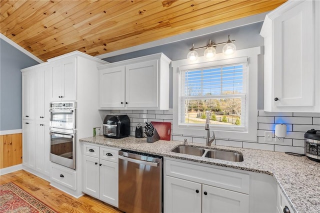 kitchen featuring sink, stainless steel appliances, light hardwood / wood-style flooring, backsplash, and white cabinets