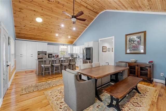 dining room featuring ceiling fan, light hardwood / wood-style floors, wooden ceiling, and high vaulted ceiling