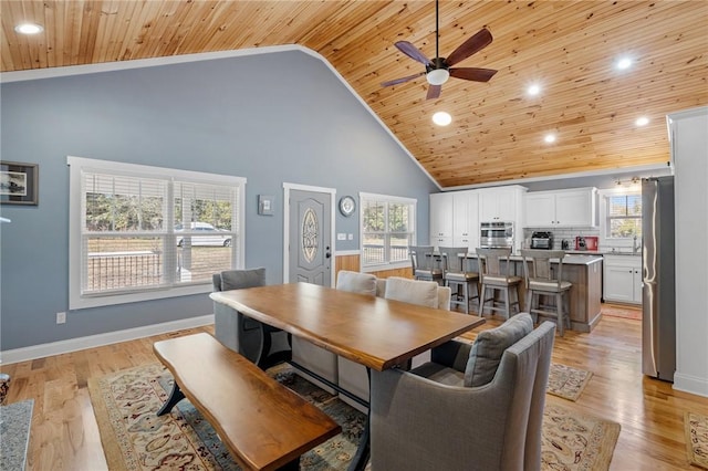 dining area featuring ceiling fan, wood ceiling, high vaulted ceiling, and light hardwood / wood-style flooring