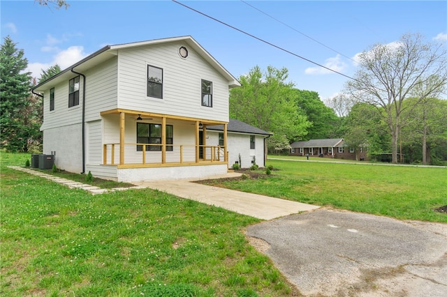 view of front of home with central AC, a porch, and a front yard