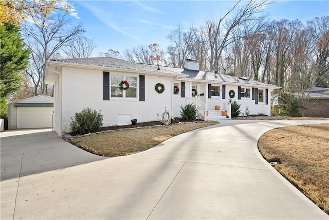 ranch-style house featuring a garage and an outbuilding