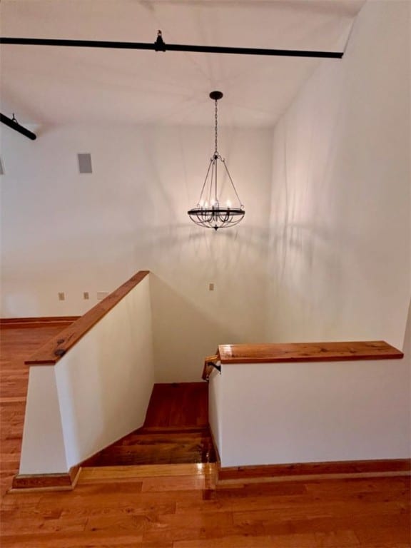 stairway with a chandelier and wood-type flooring