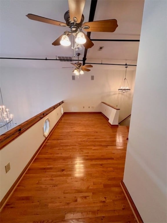 empty room featuring light wood-type flooring and an inviting chandelier