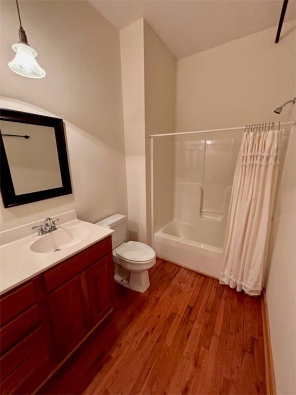 full bathroom with toilet, hardwood / wood-style floors, vanity, and shower / tub combo with curtain