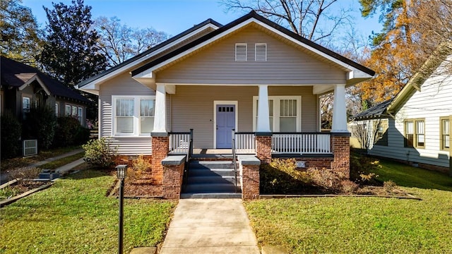 bungalow-style house with a front yard and covered porch