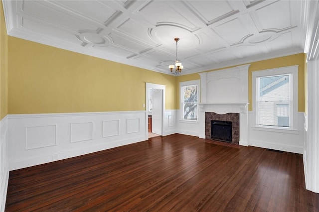 unfurnished living room featuring coffered ceiling, crown molding, dark wood-type flooring, an inviting chandelier, and a fireplace