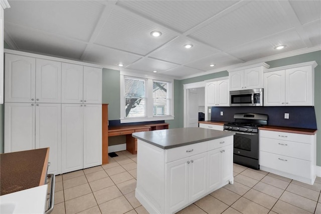 kitchen with a center island, white cabinetry, stainless steel appliances, and light tile patterned floors