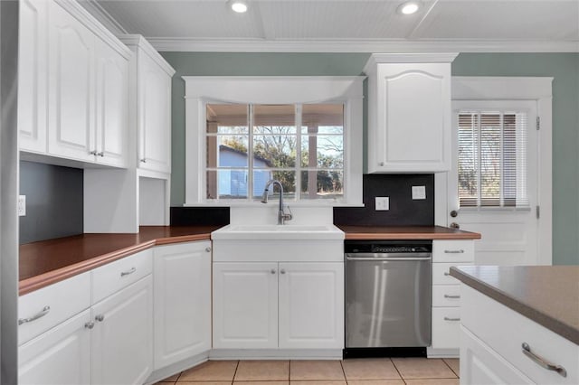 kitchen featuring stainless steel dishwasher, white cabinetry, sink, and a wealth of natural light