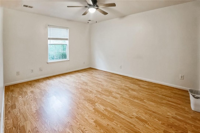 empty room with ceiling fan and light hardwood / wood-style flooring