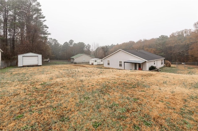 view of yard featuring a garage and an outbuilding