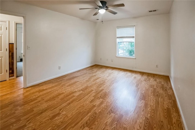 empty room with ceiling fan and light hardwood / wood-style floors