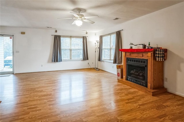 unfurnished living room with a wealth of natural light, light hardwood / wood-style flooring, and ceiling fan