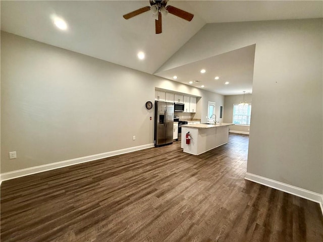 kitchen with stainless steel appliances, dark hardwood / wood-style flooring, an island with sink, white cabinets, and ceiling fan with notable chandelier