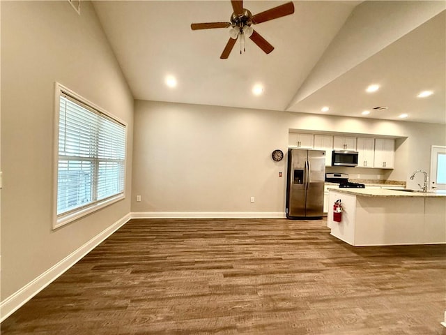 kitchen featuring dark hardwood / wood-style floors, white cabinetry, appliances with stainless steel finishes, and vaulted ceiling