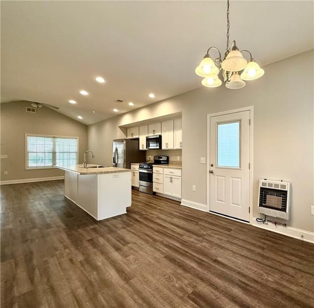 kitchen with appliances with stainless steel finishes, heating unit, vaulted ceiling, decorative light fixtures, and white cabinets