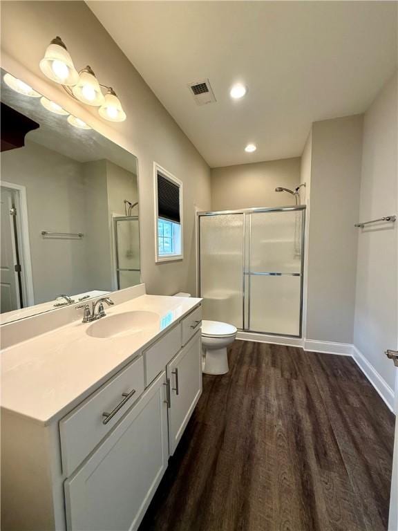 bathroom featuring hardwood / wood-style floors, vanity, toilet, and an enclosed shower