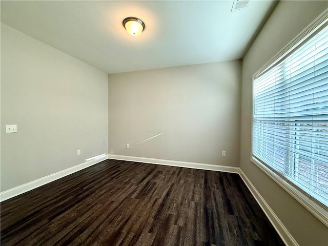 unfurnished room featuring dark hardwood / wood-style floors and a healthy amount of sunlight