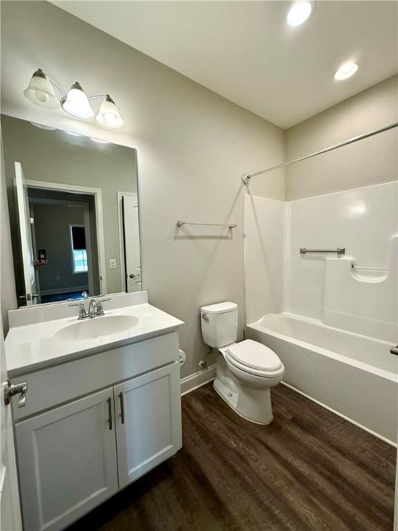 full bathroom featuring hardwood / wood-style floors, vanity, toilet, and shower / washtub combination