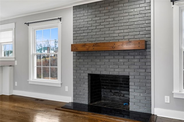 room details with a fireplace, wood-type flooring, and ornamental molding