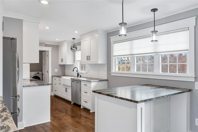 kitchen featuring decorative light fixtures, washer / dryer, white cabinetry, and stainless steel appliances