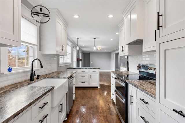 kitchen featuring pendant lighting, backsplash, dark wood-type flooring, white cabinetry, and stainless steel appliances