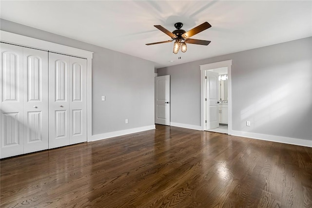 unfurnished bedroom with connected bathroom, a closet, ceiling fan, and dark wood-type flooring