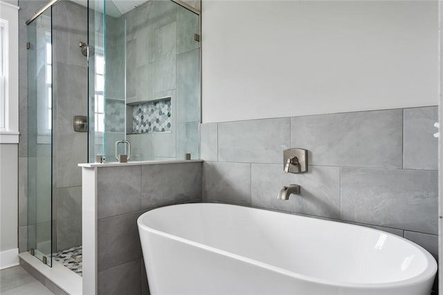 bathroom featuring tile walls and shower with separate bathtub