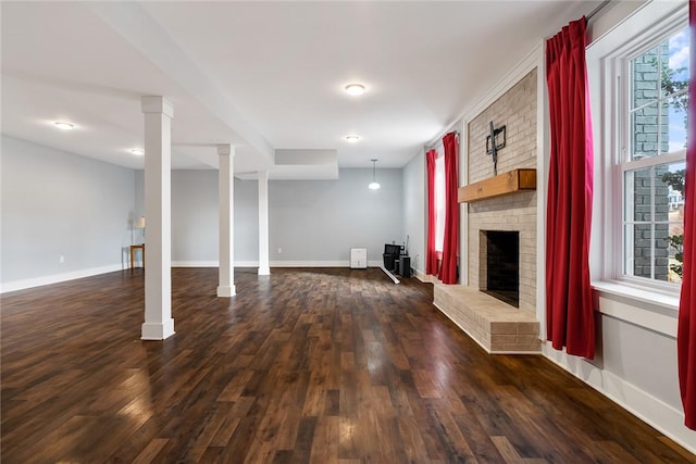 basement featuring a fireplace, dark hardwood / wood-style flooring, and a healthy amount of sunlight