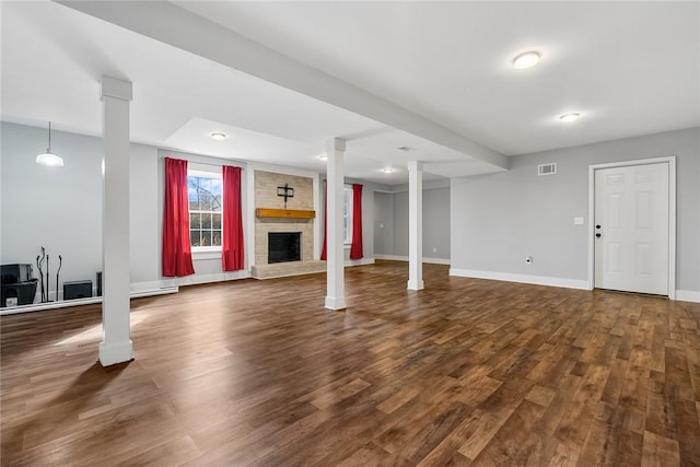 basement featuring dark hardwood / wood-style floors and a brick fireplace