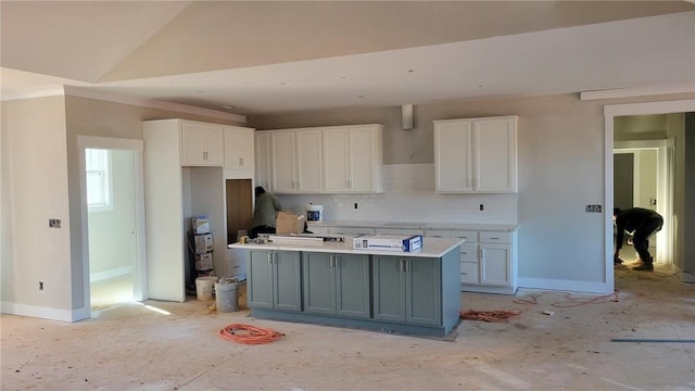 kitchen featuring lofted ceiling, gray cabinets, a kitchen island with sink, tasteful backsplash, and white cabinets