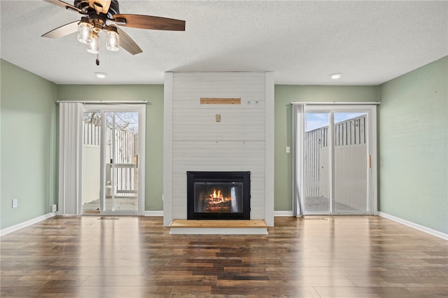 unfurnished living room featuring a textured ceiling, dark hardwood / wood-style floors, and a fireplace