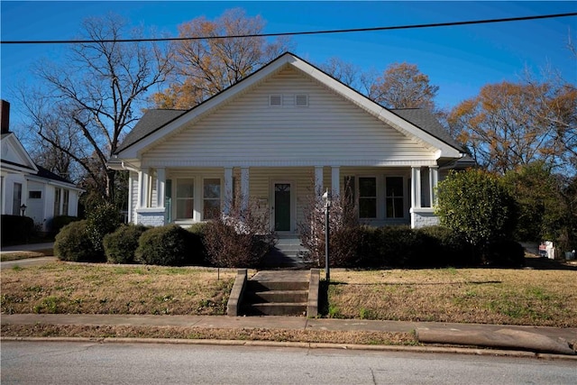 bungalow-style house with a porch and a front lawn