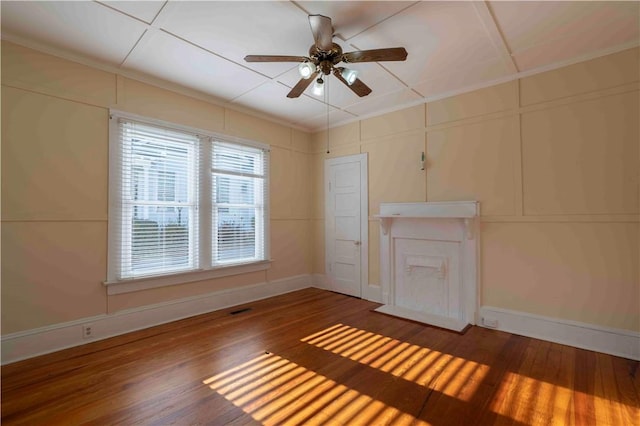 spare room featuring dark hardwood / wood-style flooring, ceiling fan, and ornamental molding