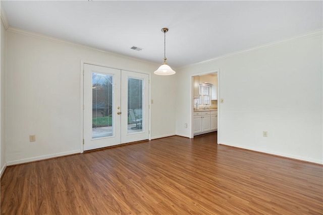 spare room with dark hardwood / wood-style floors, ornamental molding, and french doors