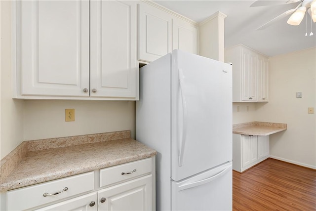 kitchen with white cabinetry, white fridge, light hardwood / wood-style floors, and ceiling fan