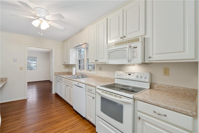 kitchen with white cabinets, white appliances, light hardwood / wood-style floors, and sink