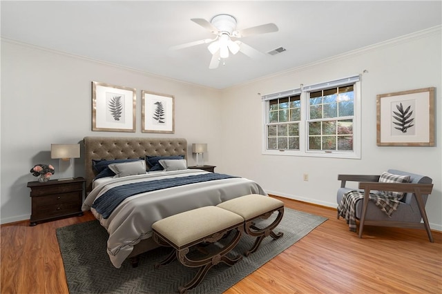 bedroom with ceiling fan, wood-type flooring, and ornamental molding