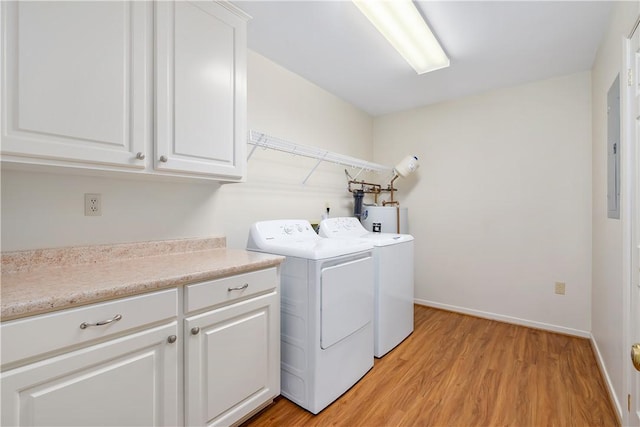 laundry area with washer and dryer, cabinets, light wood-type flooring, and water heater