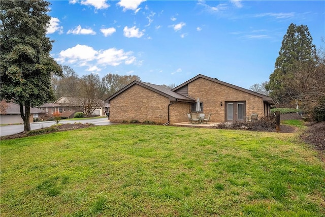 back of property with a lawn and a patio area