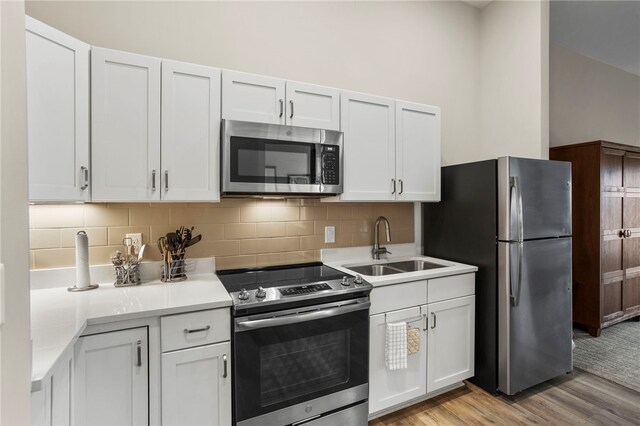 13500 Clemson Blvd Unit 2108, Seneca, SC 29678 - kitchen with decorative backsplash, appliances with stainless steel finishes, sink, light hardwood / wood-style floors, and white cabinetry