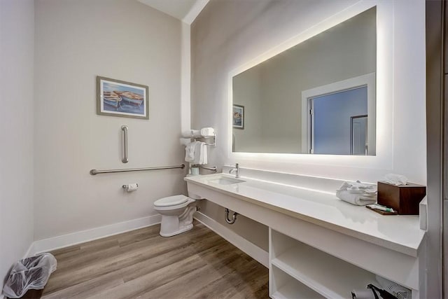 bathroom with sink, toilet, and hardwood / wood-style flooring