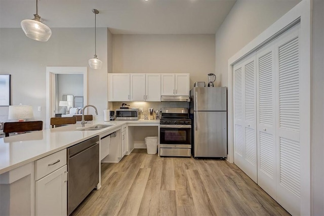 kitchen featuring white cabinets, pendant lighting, stainless steel appliances, and sink