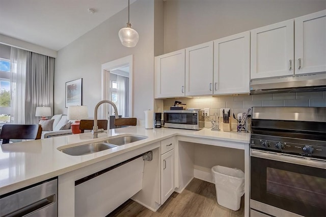 kitchen with white cabinets, pendant lighting, sink, and stainless steel appliances