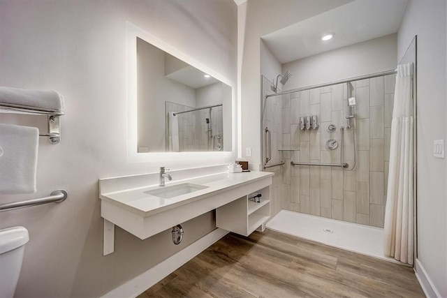 bathroom featuring sink, a shower with shower curtain, wood-type flooring, and toilet