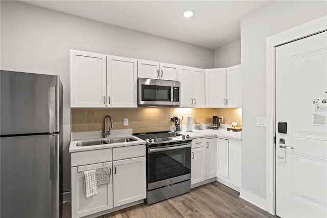 kitchen featuring white cabinets, hardwood / wood-style floors, stainless steel appliances, and sink