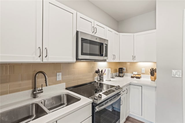 kitchen with backsplash, sink, white cabinets, and stainless steel appliances