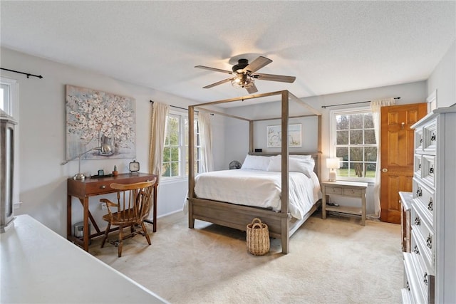 carpeted bedroom with ceiling fan and a textured ceiling