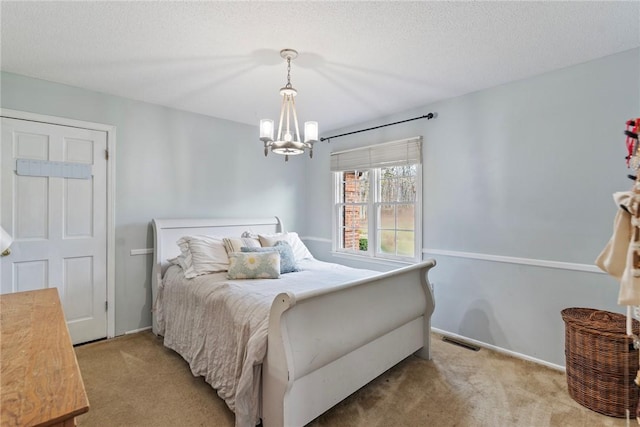 carpeted bedroom with a textured ceiling and a notable chandelier