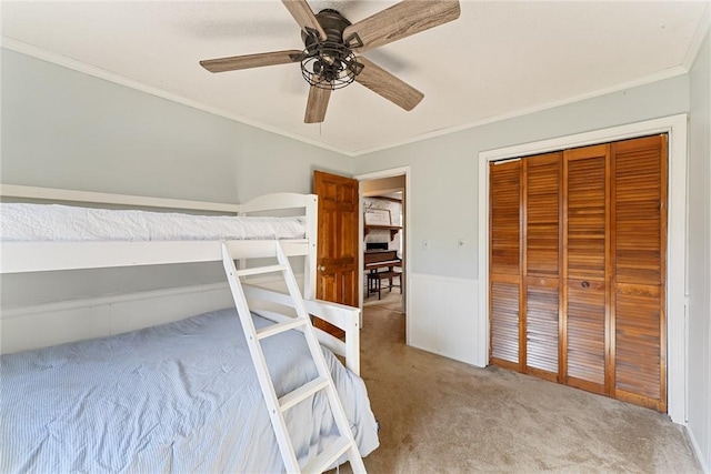 unfurnished bedroom with a closet, ceiling fan, crown molding, and light colored carpet